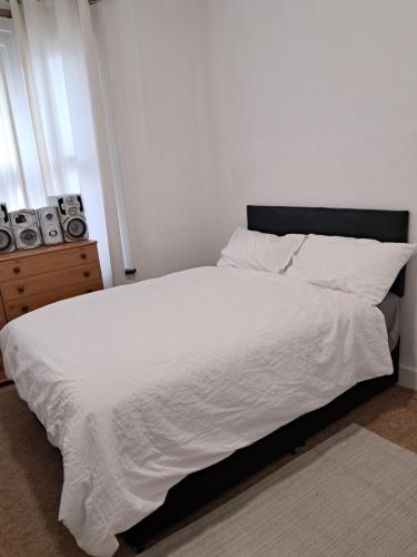 a bedroom with a bed with white sheets and pillows at New 2BED Kay Road SW9 London in London