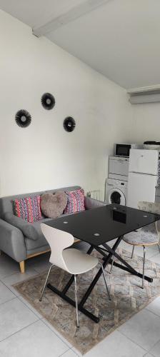 un salon avec une table et un canapé dans l'établissement APPARTEMENT JARDIN, à Parc Saint-Maur