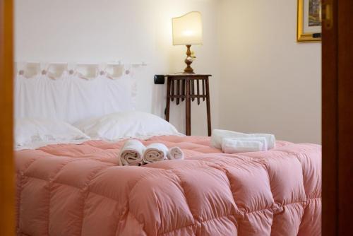 a pink bed with shoes on top of it at Casa sulla via di Francesco in Gubbio