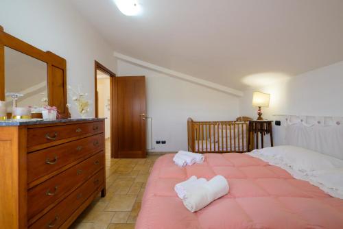 a bedroom with a large bed with a dresser and a mirror at Casa sulla via di Francesco in Gubbio