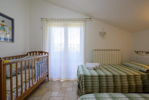 a bedroom with two twin beds and a crib at Casa sulla via di Francesco in Gubbio