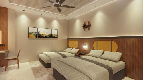 a bedroom with two beds and a ceiling fan at Hotel Shakuntla Grand in Gaya