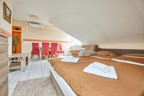 een slaapkamer met 2 bedden en een tafel en stoelen bij ADA Apartmanház in Hajdúszoboszló