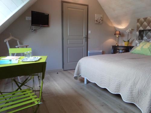 a bedroom with a bed and a desk and a tv at Les Gites de Kerdurod in Guidel