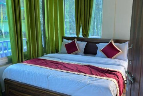 1 dormitorio con 1 cama grande y cortinas verdes en Goroomgo Morning Moon Bhimtal Near Ramleela Ground - Comfortable Stay with Family, en Bhimtal
