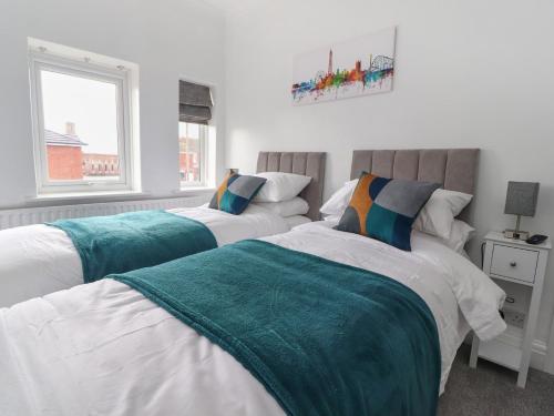 two beds in a bedroom with white walls at 12 Pennystone Road in Blackpool