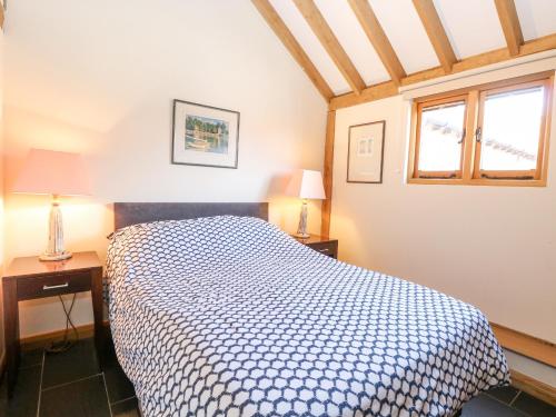 a bedroom with a bed and two tables and a window at 5a Hideaways in Hunstanton