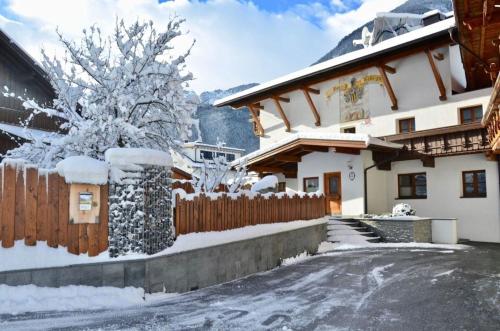 een huis met een hek in de sneeuw bij Großzügiges Ferienhaus in Umhausen mit Garten, Grill und Terrasse in Umhausen