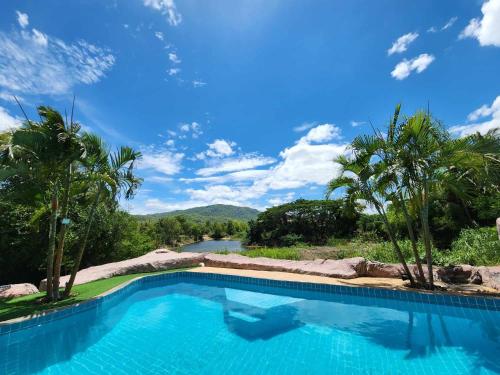 ein Schwimmbad mit einem Fluss im Hintergrund in der Unterkunft ฺBuena Vista Pool Villa Hua Hin (บ้านพักหัวหิน) in Hua Hin