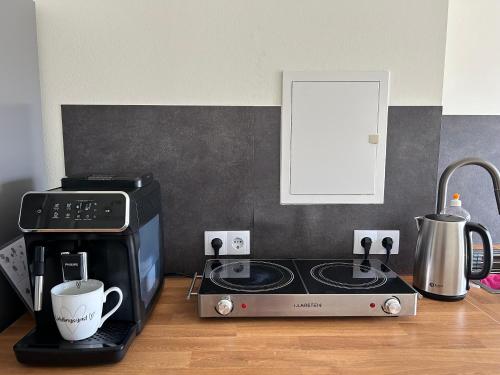 a kitchen counter with a stove and a coffee maker at Schöne neue 4 Zimmer Wohnung mit Süd-Balkon bis 8 Personen in Naumburg