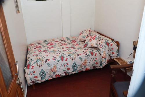 a small bed in a corner of a room at Green Heart Homestay in Nuwara Eliya