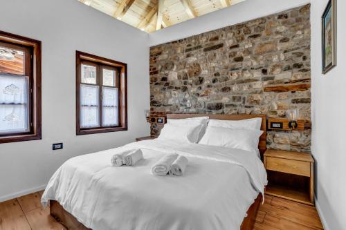 a bedroom with a large white bed with towels on it at Vila Meri in Berat