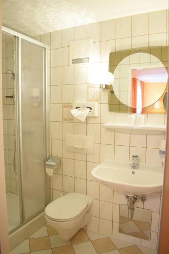a bathroom with a toilet and a sink and a shower at Gartenhotel Kloepferkeller in Eibiswald