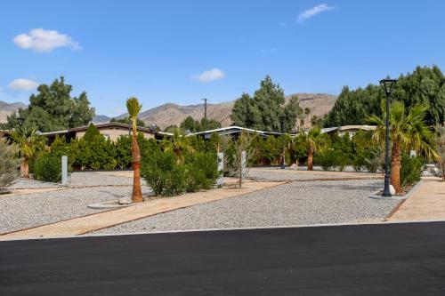 una calle vacía con palmeras y un edificio en RV51-Lot-Paradise RV Park en Desert Hot Springs
