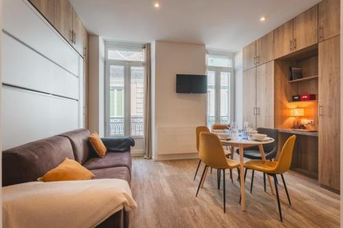 un salon avec un canapé, une table et des chaises dans l'établissement Studio Familial Entièrement Rénové Cauterets Centre, à Cauterets