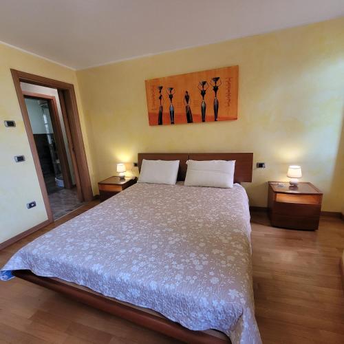 コスタ・ヴォルピーノにあるIl Cortiletto Mountain Lake Iseo Hospitalityのベッドルーム1室(ベッド1台、ナイトスタンド2台、ランプ2つ付)