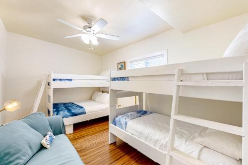 two bunk beds in a room with a ceiling fan at Old Town Treasure in Port Aransas