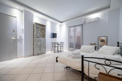 ein weißes Zimmer mit 2 Betten und einem Tisch in der Unterkunft Kastella cozy flat for 2 persons my MPS in Piräus