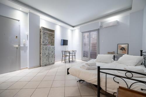 Habitación blanca con 2 camas y mesa en Kastella cozy flat for 2 persons my MPS, en Pireo