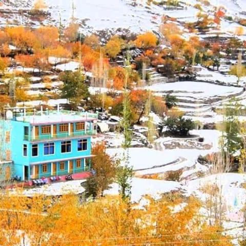 a blue house on top of a snow covered hill at KAPEL Inn HOTEL in Nagir
