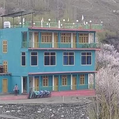 a blue building with a person standing in front of it at KAPEL Inn HOTEL in Nagir