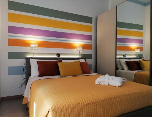 ein Schlafzimmer mit einem Bett mit einer bunten gestreiften Wand in der Unterkunft Appartement in Varesche mit Privatem Garten und Panoramablick in Costermano sul Garda