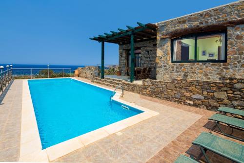a swimming pool in front of a stone house at Amazing sea views at villa Elafonissi with private pool, near Elafonissi beach in Chania