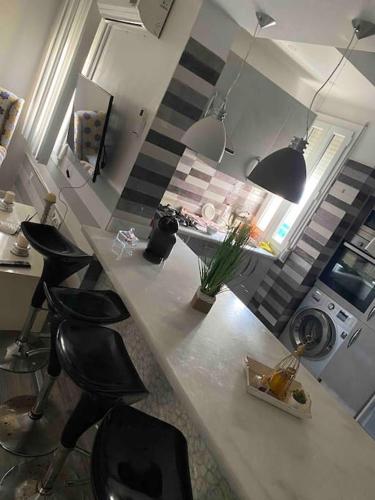 a kitchen with a counter with black stools at Nador Holiday in Selouane