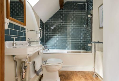a bathroom with a sink and a toilet and a tub at Slatters Cottage - 17th Century Cotswolds Cottage in Bourton on the Hill