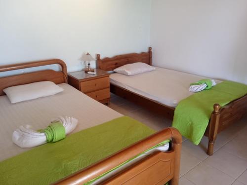 1 Schlafzimmer mit 2 Betten und grüner Bettwäsche in der Unterkunft INFO στούντιο in Messini