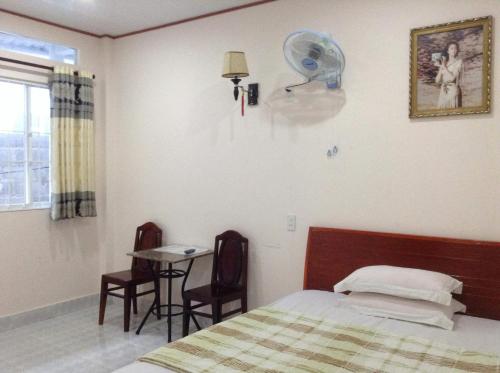Un dormitorio con una cama, una mesa y un ventilador. en 247C/A Guest House, en Mui Ne