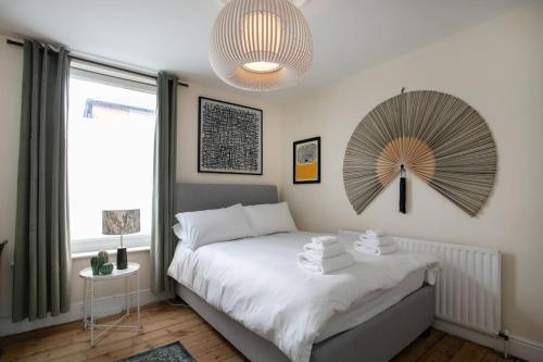 una camera da letto con un letto e un grande ventilatore a muro di Stylish 4 Bed Home In Central Nottingham w/Parking a Nottingham