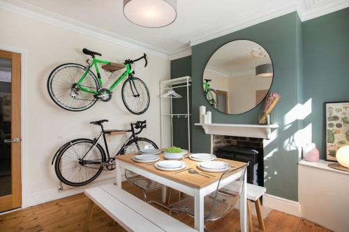 a dining room with a table and two bikes on the wall at Stylish 4 Bed Home In Central Nottingham w/Parking in Nottingham