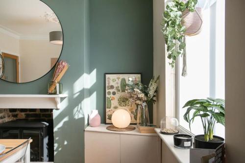 a kitchen with green walls and a counter with a mirror at Stylish 4 Bed Home In Central Nottingham w/Parking in Nottingham