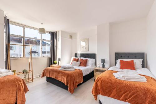 a bedroom with two beds with orange sheets at Ivy House - 3 Bedroom House - Contractor Stay in Bristol