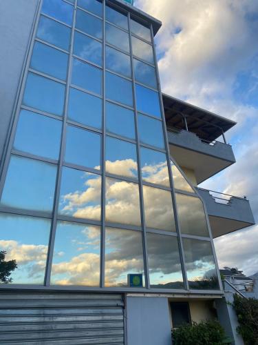 a building with a reflection of the sky in the window at Qiqi Hotel in Gjirokastër