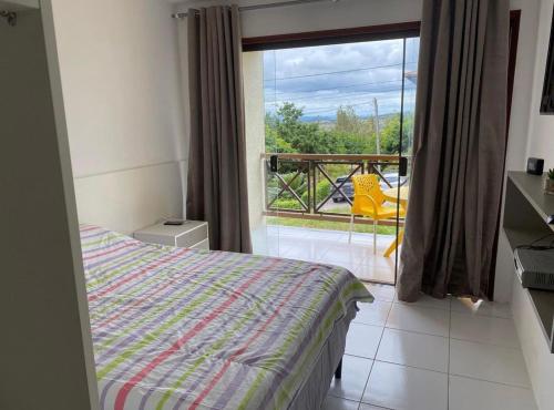 um quarto com uma cama e uma varanda com vista em Flat 1218, no residencial monte castelo em Bezerros