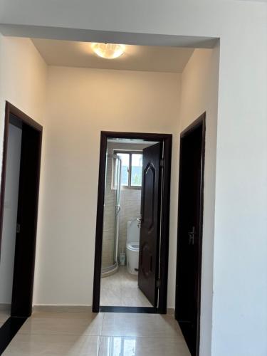 a hallway with a bathroom with a toilet and a mirror at Bienvenue au centre-ville de Libreville in Libreville