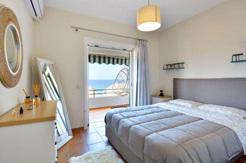 Two-bedroom Condo with Sea View in Glyfada في غليفادا: غرفة نوم مع سرير وإطلالة على المحيط