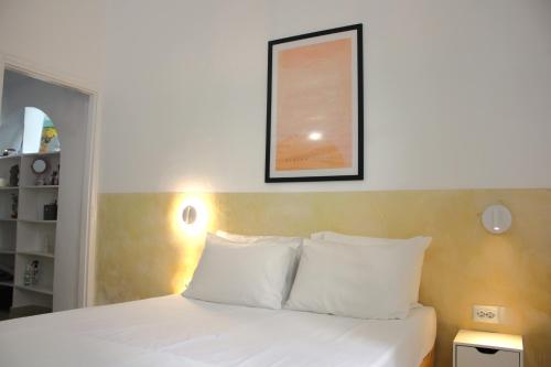 - un lit avec des oreillers blancs et une photo sur le mur dans l'établissement Lithi Stylish Apartments- Cosy, à Trypiti