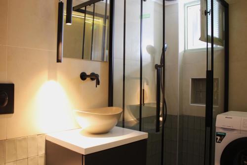 y baño con lavabo y ducha. en Lithi Stylish Apartments- Cosy en Tripití