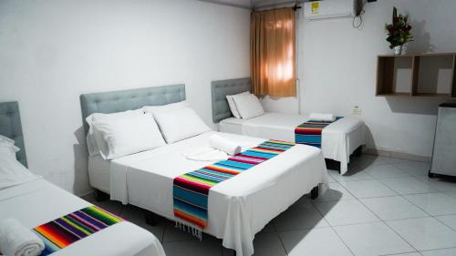 a room with two beds and a couch at Hotel Playa Divina in Coveñas