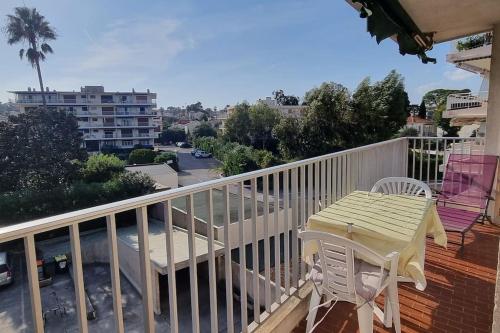 une terrasse blanche avec une table et des chaises sur un balcon dans l'établissement appartement plage de la Salis, à Antibes