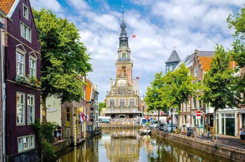 una ciudad con una torre de reloj y un río con edificios en Vakantiehuis Egmond aan Zee met parkeerplaats, en Egmond aan Zee