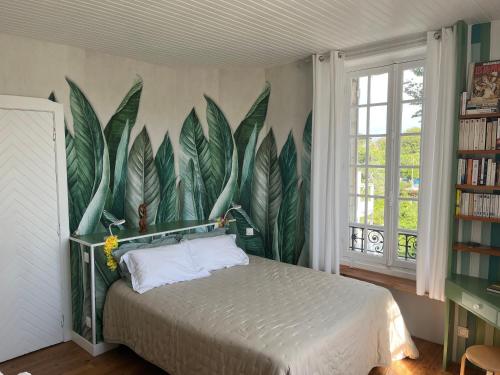 a bedroom with a bed with a mural of leaves at Villa AJNA Bayonne in Bayonne
