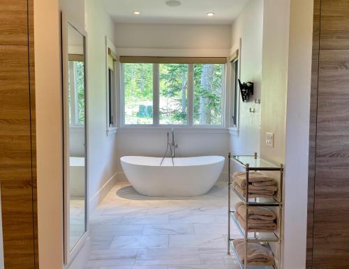een badkamer met een bad en een raam bij The Finest Expression of Mountain Homes, Ski In Out, Hot Tub in The Colony in Park City