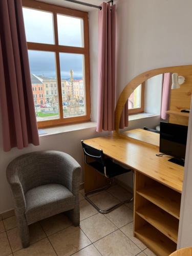 a desk and a chair in a room with a window at Hotel Praha in Broumov