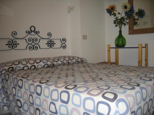 a bed in a room with a vase of flowers at L'Isolana Case Vacanza Alloro 2 in Ponza
