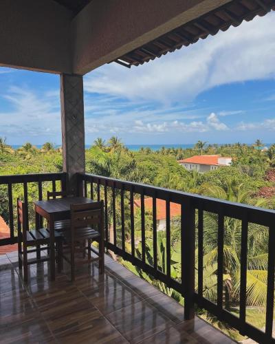 a balcony with a table and a view of the ocean at Pipa Golfinhos Pousada in Pipa