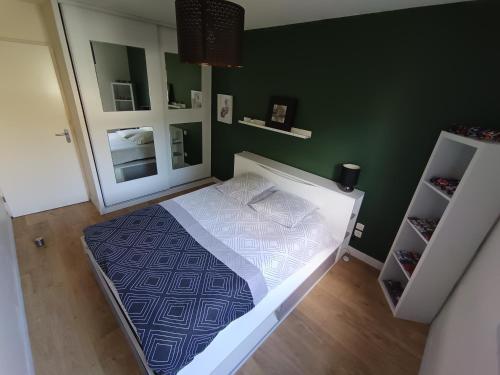 une chambre avec un lit et un mur végétal dans l'établissement Spacieux T3 cosy avec clim et terrasse à Toulouse, à Toulouse